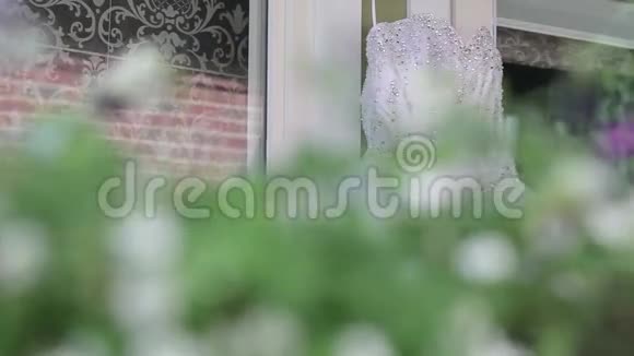 婚礼前一天白色婚纱挂在白色木屋背景上贴在白色墙壁上视频的预览图