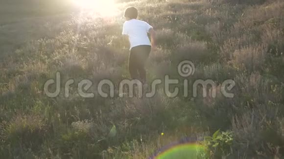 当男孩跑到山坡上时太阳的光芒使你目眩视频的预览图
