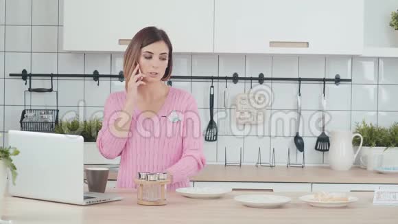 女人花时间在厨房准备晚餐打电话视频的预览图