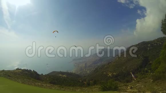 几个滑翔伞在山上漂流到海滨城市极端视频的预览图