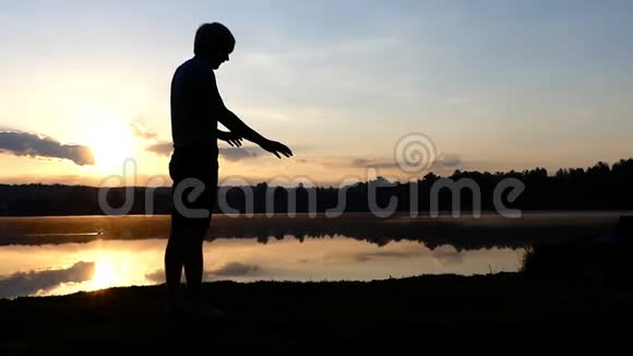 年轻人站在他的手上在夕阳下散步视频的预览图