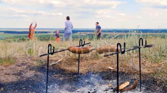 接近谁做肉香肠的镜头他们是在一个夏日的草地上的火中煎的火火烧得厨师视频的预览图