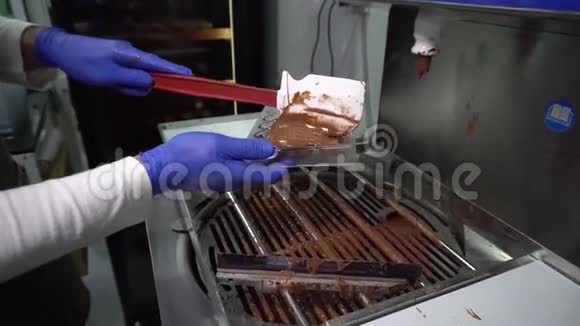 工人用融化的巧克力填充模具制作巧克力的过程视频的预览图