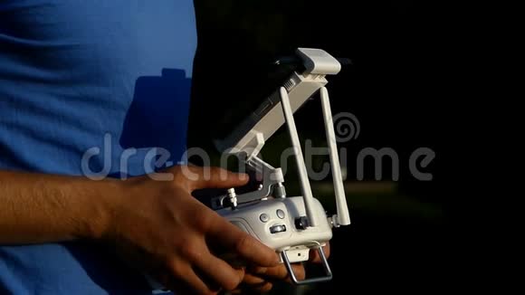 雄手操纵一架无人驾驶飞机在太阳落山时带有控制面板视频的预览图