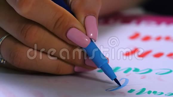 书法学生练习在画布上用蓝色标记书写单词美创意艺术家自由职业者视频的预览图
