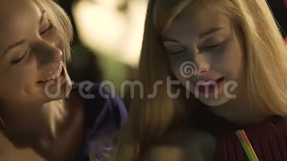 两个漂亮的女孩在夜总会喝酒的时候打字笑着发短信视频的预览图