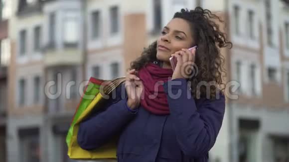 年轻的混血女人带着购物袋叫出租车对购买感到满意视频的预览图