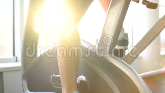 女性健身腿训练健身自行车在美丽的太阳升起的背景下视频的预览图
