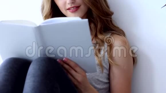 快乐的年轻女子在家放松和看书视频的预览图