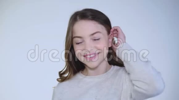 漂亮的女孩把头发放在耳朵后面对着镜头微笑视频的预览图