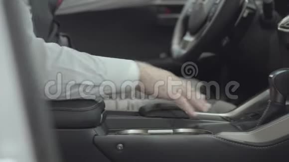不认识的自信男人坐在车里检查从汽车经销商那里新购买的汽车汽车视频的预览图