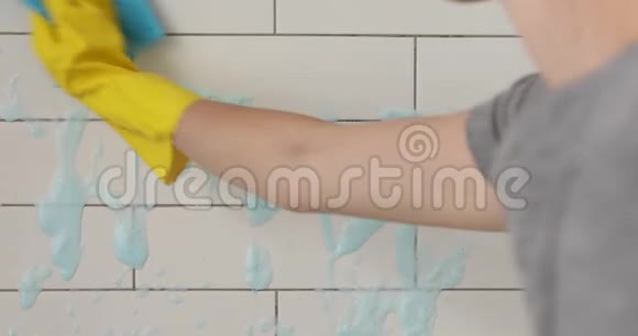 浴室特写中的手清洁瓷砖表面视频的预览图