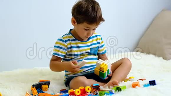 慢动作亚洲男孩玩彩色建筑塑料块在白色床上在家里视频的预览图