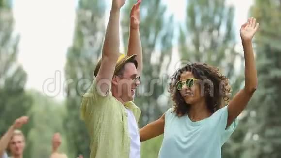 年轻的男女在户外音乐中跳舞手举在空中视频的预览图