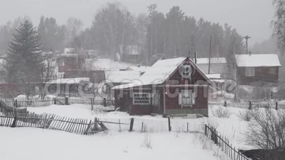 冬天下雪时靠近森林的乡村房屋视频的预览图