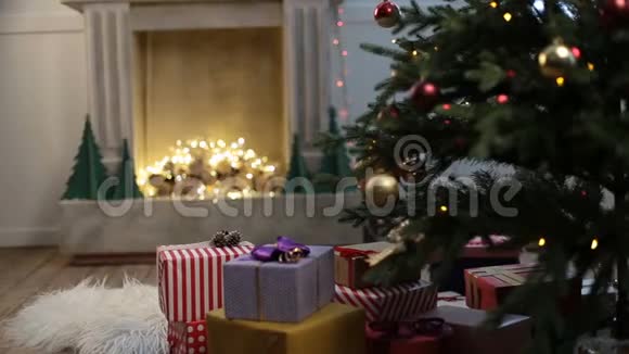 可爱的小女孩在圣诞树下寻找礼物视频的预览图