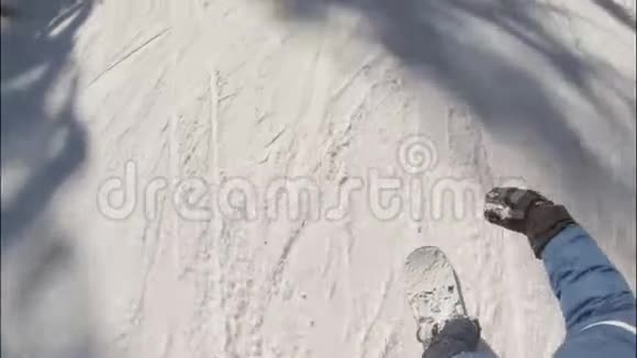 年轻人滑雪板滑下雪林坡视频的预览图