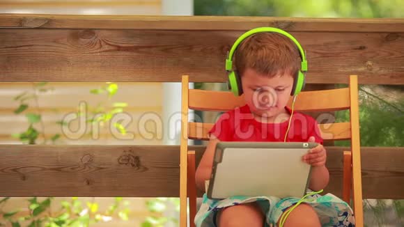 听绿色耳机音乐的男孩视频的预览图