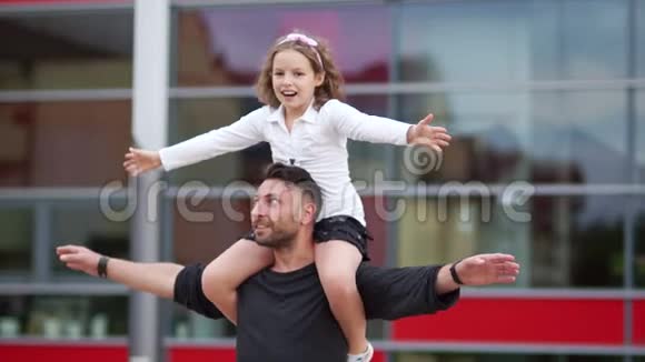 一个漂亮的卷发男孩从背后拥抱他的父亲父亲节幸福的家庭视频的预览图