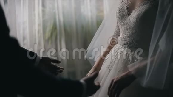 新婚夫妇双手握在窗前视频的预览图