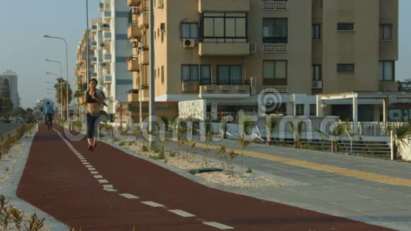 苗条的女士沿着城市道路慢跑积极的生活方式促进健康和健康视频的预览图