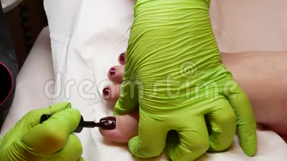 近距离放松和美容概念掌握绿色手套的修脚涂指甲油专业修脚术视频的预览图