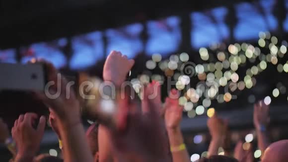 音乐会上的音乐迷人们鼓掌和制作手机视频视频的预览图