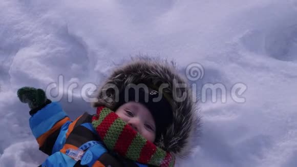 那孩子躺在雪地里做雪天使视频的预览图
