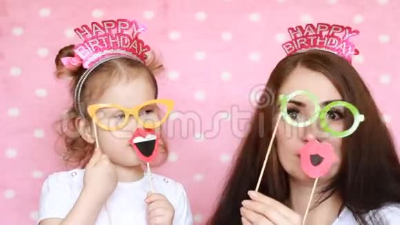 幸福的家庭母亲和女儿穿着眼镜和嘴唇和不同的装饰来庆祝生日这就是视频的预览图