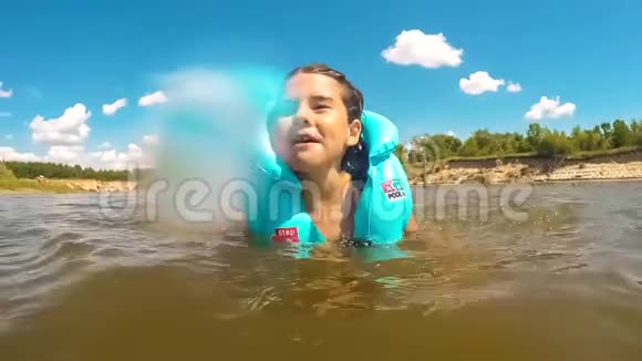 女孩在水里玩小女孩在湖里洗澡快乐河里正在学习游泳暑期儿童概念视频的预览图