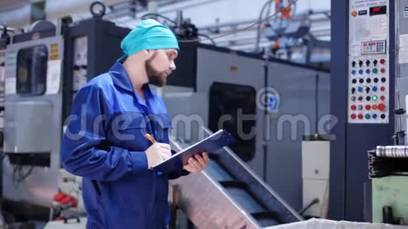 工厂机器附近有剪贴板的工人视频的预览图