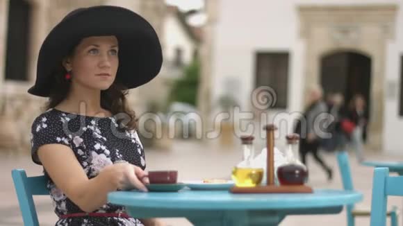 年轻的调情女性在漂亮的街边咖啡馆里微笑着喝咖啡视频的预览图
