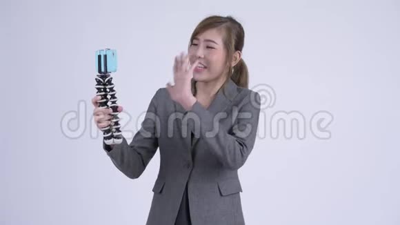 年轻快乐的亚洲女商人vlog和展示电话视频的预览图