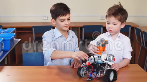 两个兄弟的孩子在学校机器人课上玩机器人玩具室内视频的预览图