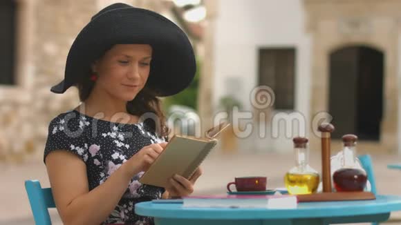 美丽的年轻女子读有趣的书用钢笔标出最喜欢的地方视频的预览图