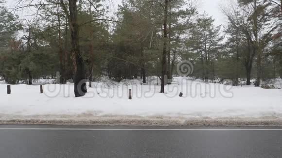 年轻迷人的白种人女孩在冬天带着耳机在雪地公园跑步侧面射击视频的预览图