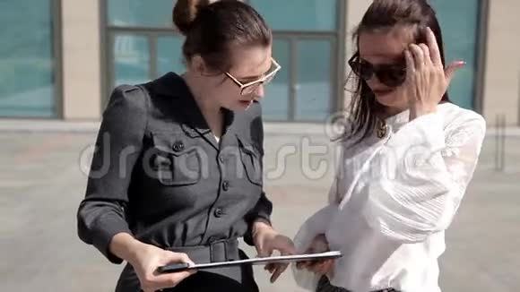 两个年轻的商务女孩在商务中心附近的公园进行商务谈判工作事务视频的预览图