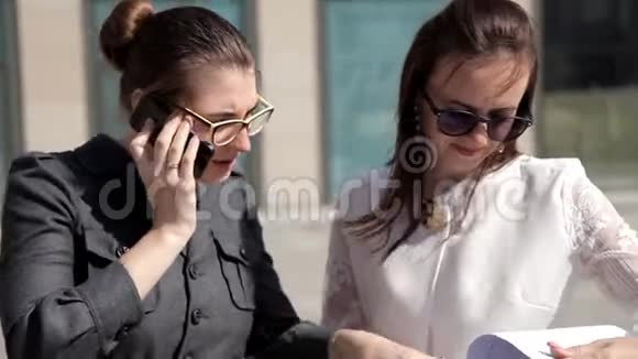 两个年轻的商务女孩在商务中心附近的公园进行商务谈判工作事务视频的预览图
