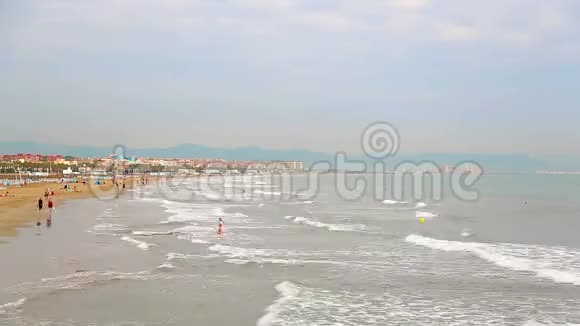 时光流逝的海滩上有游客休息海浪很快来到岸边度假者在黄沙上行走视频的预览图