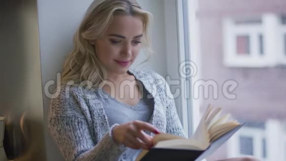 女人在窗户附近看书视频的预览图