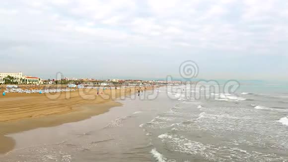 时光流逝的海滩上有游客休息海浪很快来到岸边度假者在黄沙上行走视频的预览图