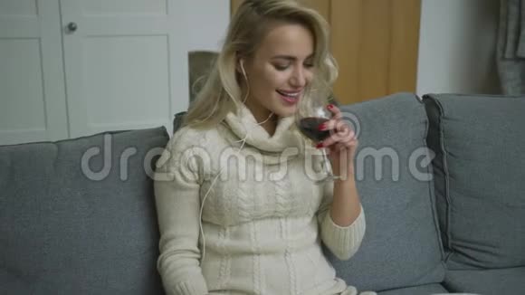 微笑的女人带着酒听音乐视频的预览图