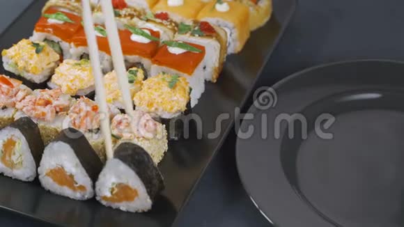 女人把寿司卷放在盘子里桌子上摆着一大套卷日本食品视频的预览图