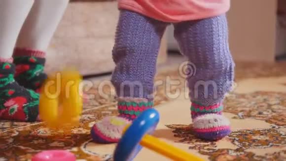 小女孩投掷和收集玩具专注于腿和彩色戒指视频的预览图