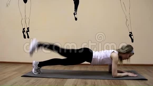 穿着运动服的漂亮女孩做伸展运动躺着视频的预览图