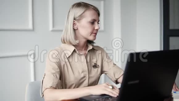 年轻女性在现代咖啡馆工作这是自由职业者的办公室时尚的成年女性辛勤工作的文件视频的预览图