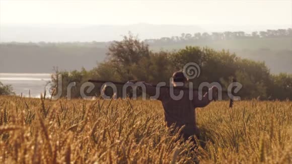 农妇手持农具日出时穿过麦田视频的预览图