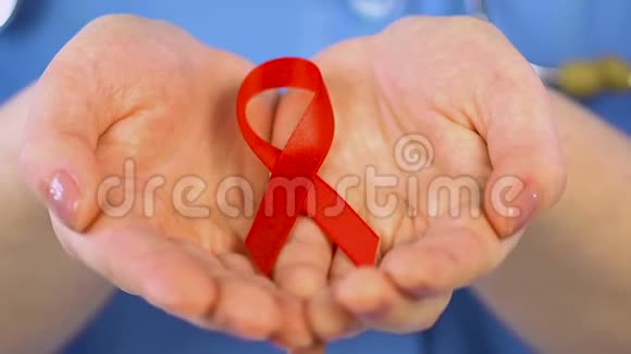 持有红丝带的女医生照顾和保护艾滋病毒阳性儿童视频的预览图