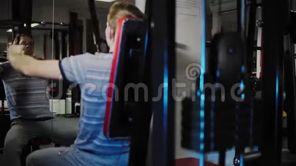 年轻人在健身房里用胸蝇机视频的预览图