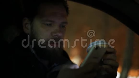 大胡子男人喝咖啡在车里用电话视频的预览图